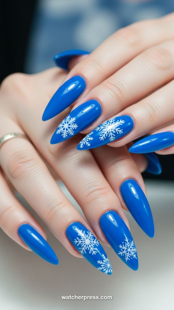 Precision Application: Achieving Flawless Royal Blue Stiletto Nails with Winter Snowflake Gel Art