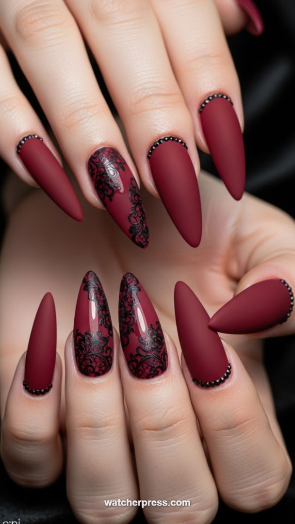Vampy Elegance: Matte Burgundy Stiletto Nails with Intricate Black Lace and Micro-Pearl Accents